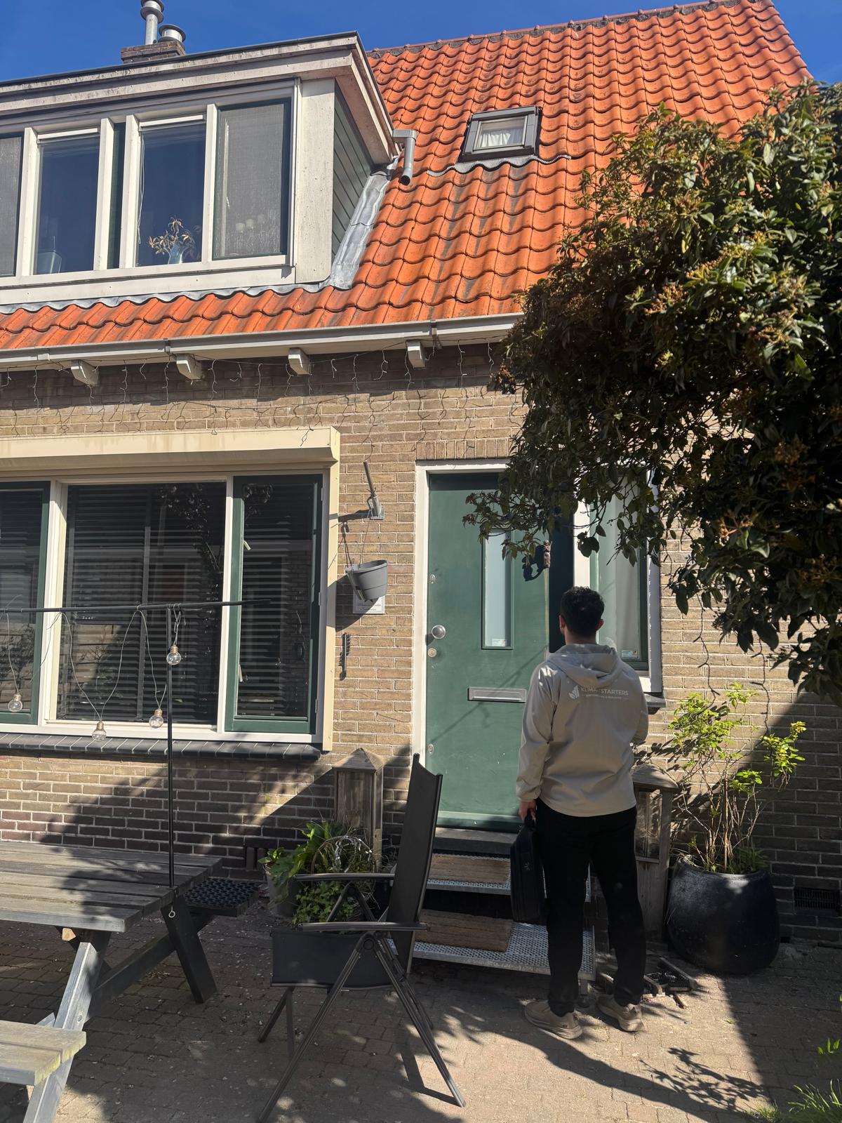 Klimaatstarters-adviseur aan de voordeur van een Zaanse woning voor gratis verduurzamingsadvies